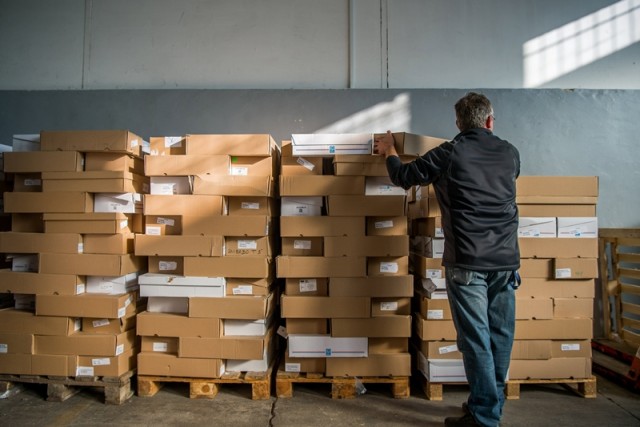 A visszaküldött nemzeti konzultációs kérdőíveket tartalmazó dobozokat rendezi egy szakember a Nemzeti Infokommunikációs Szolgáltató Zrt. XIV. kerületi telephelyén 2017. december 2-án. MTI Fotó: Balogh Zoltán
