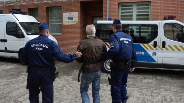 Rendőrök vezetik a gyanúsítottat
